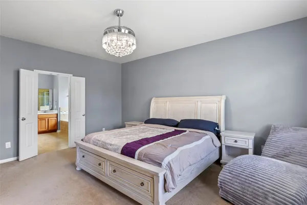 a spacious bedroom with two bed and a chandelier