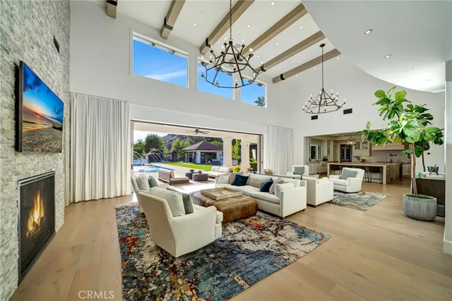 a large white kitchen with a large counter top space a sink stainless steel appliances and cabinets