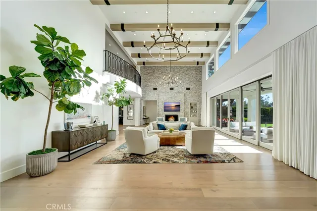 a living room with furniture a chandelier and a fireplace