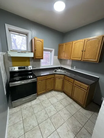 a kitchen with a sink a stove top oven and cabinetry