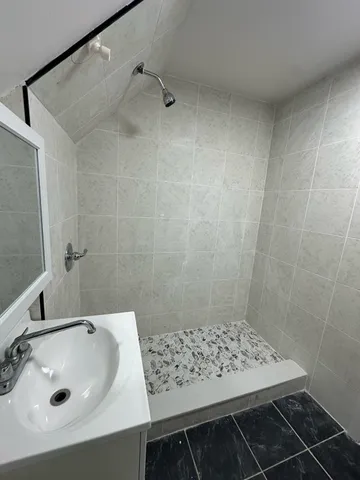 a view of a roof deck with couches and wooden fence