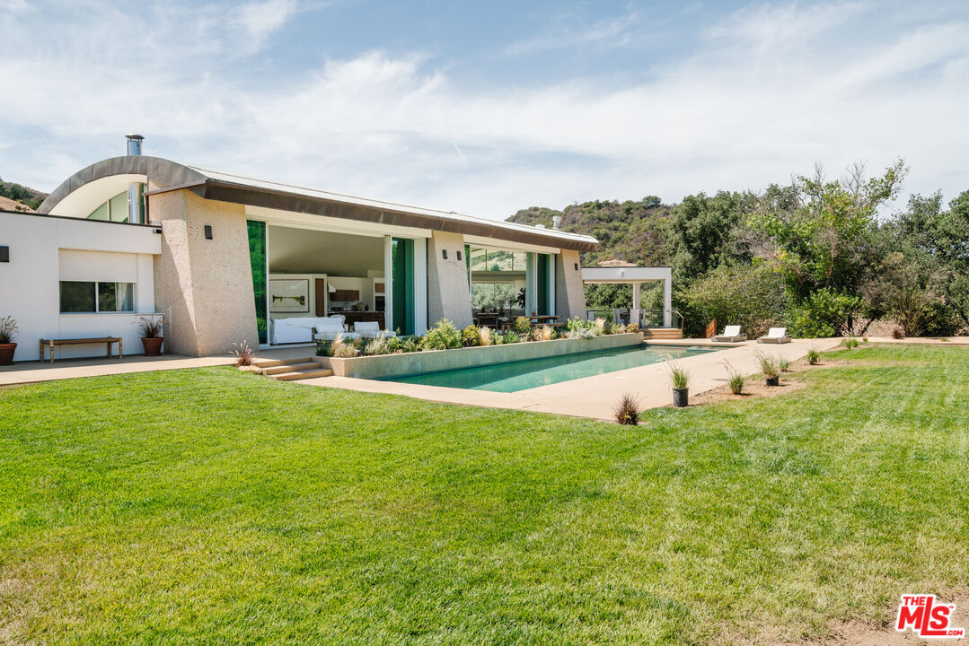1750 Will Geer Road Topanga, CA 90290 - Photo 22 of 49 a view of swimming pool with outdoor seating and house in the background