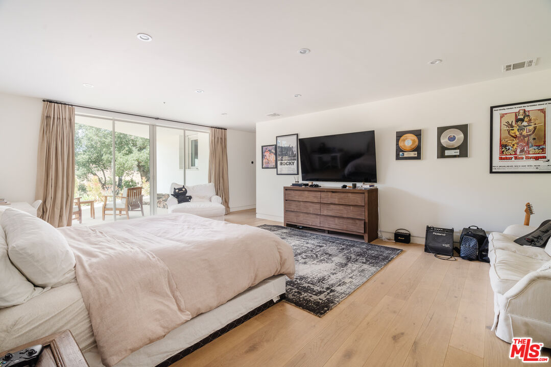 1750 Will Geer Road Topanga, CA 90290 - Photo 35 of 49 a bedroom with a bed and a flat screen tv
