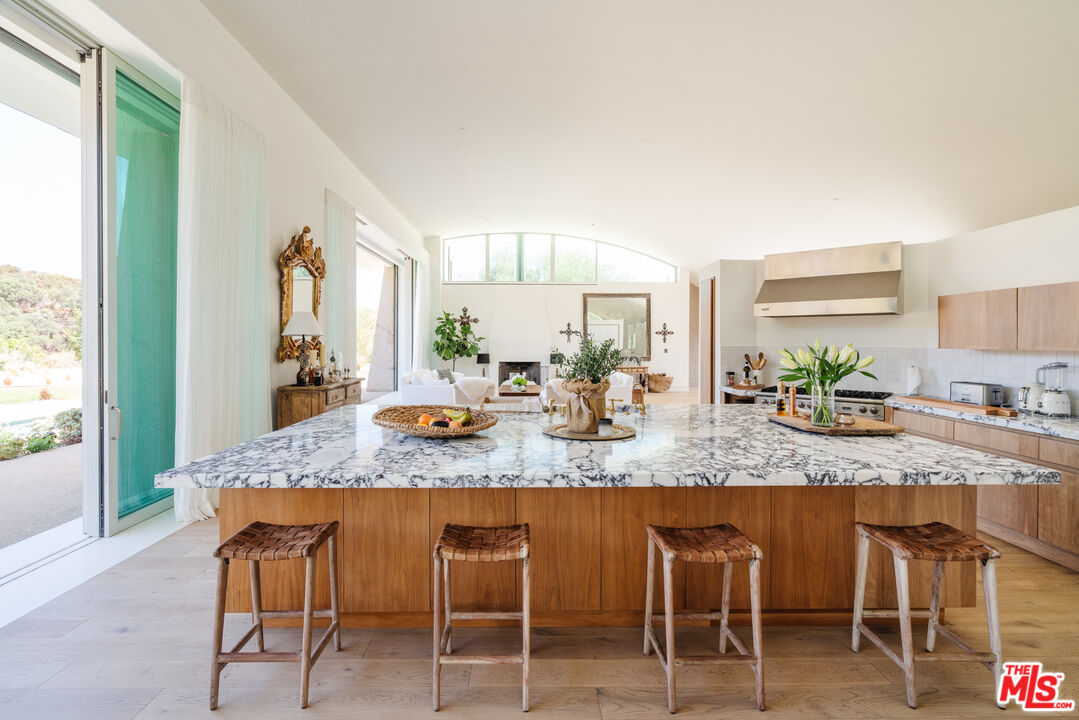 1750 Will Geer Road Topanga, CA 90290 - Photo 6 of 49 a kitchen with granite countertop sink table and chairs