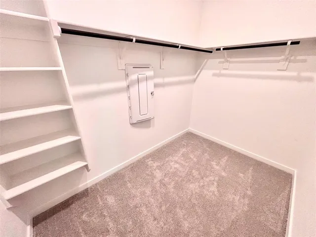 view of a room with wooden floor and a hallway