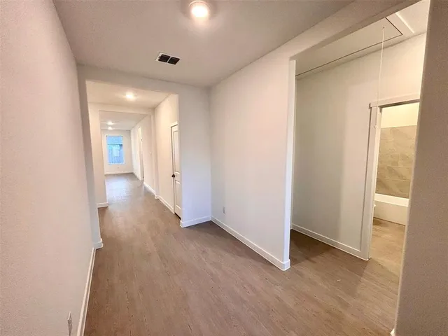 a view of a hallway with wooden floor