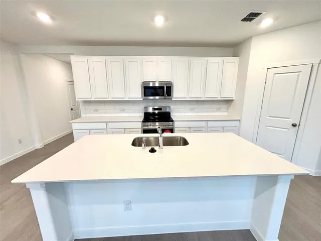 a view of kitchen with refrigerator sink and wooden floor