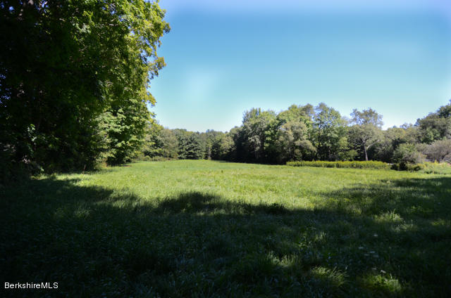 a view of a green field with wooden fence