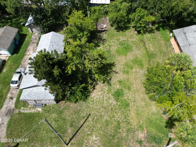 an aerial view of a residential houses with yard