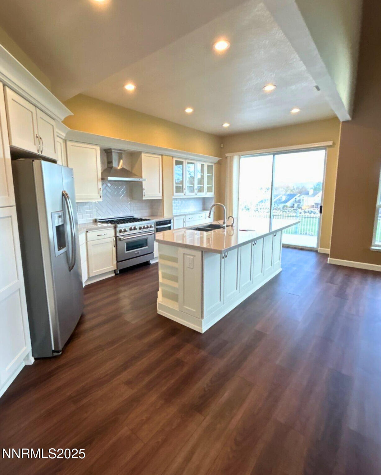6190 Carriage House Way Reno, NV 89519 - Photo 4 of 26 a kitchen with stainless steel appliances granite countertop wooden floors and white cabinets