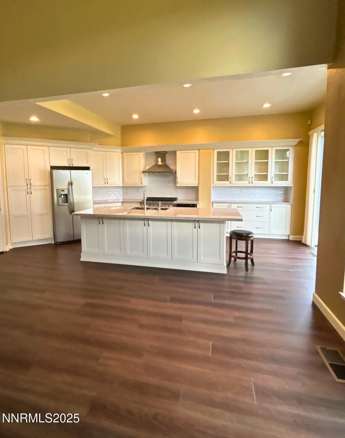 6190 Carriage House Way Reno, NV 89519 - Photo 5 of 26 a view of a kitchen with kitchen island a sink wooden floor and a counter top space