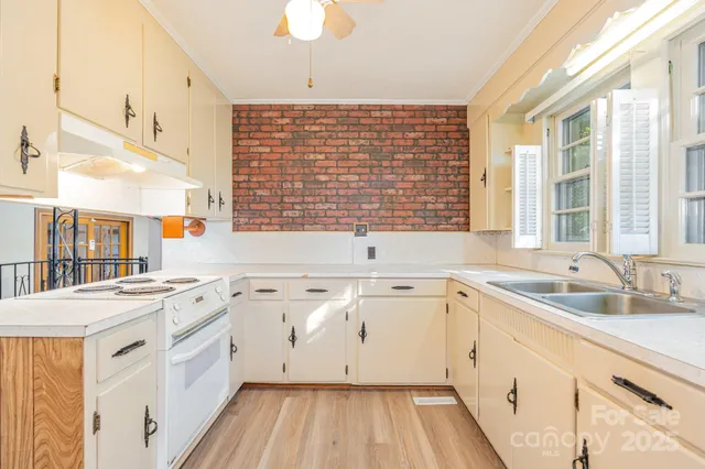 a kitchen with a sink stove top oven and cabinets