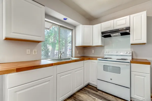 a kitchen with granite countertop white cabinets and white appliances