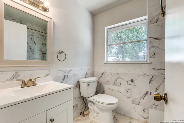 a bathroom with a toilet sink and mirror