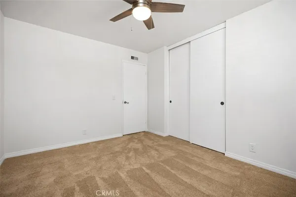 a view of a room with a ceiling fan and a window