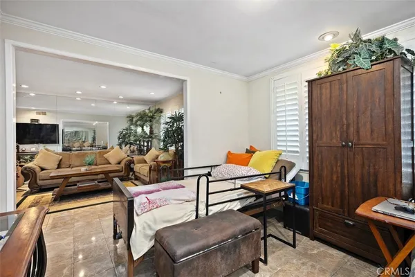 a living room with furniture a flat screen tv and a window