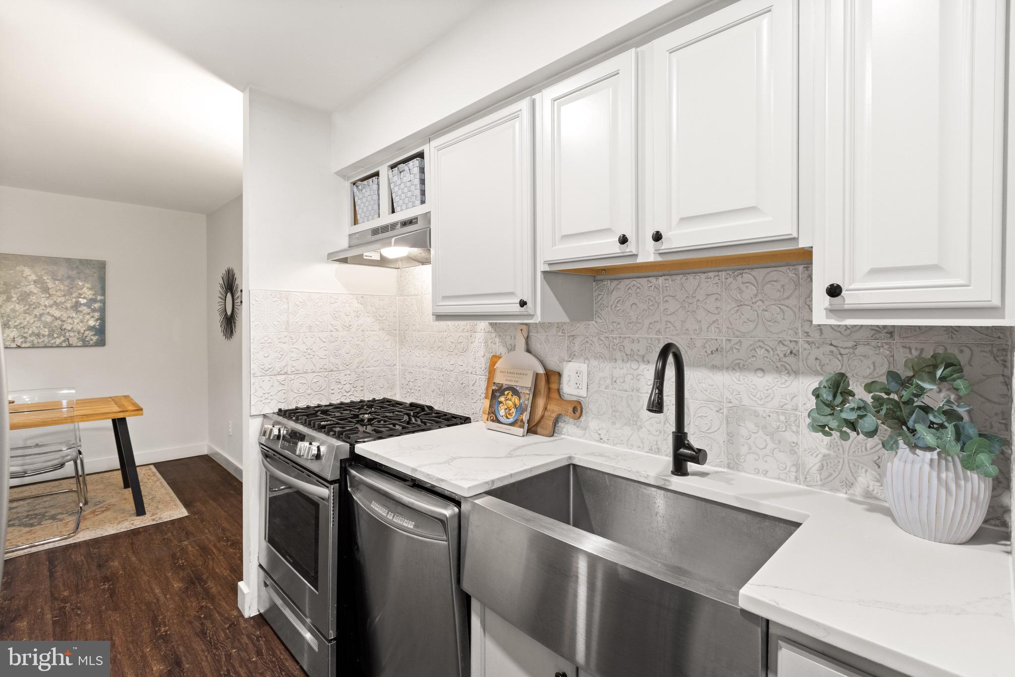 11240 Chestnut Grove Square, Unit 358 Reston, VA 20190 - Photo 13 of 31 a kitchen with granite countertop a sink a stove and cabinets