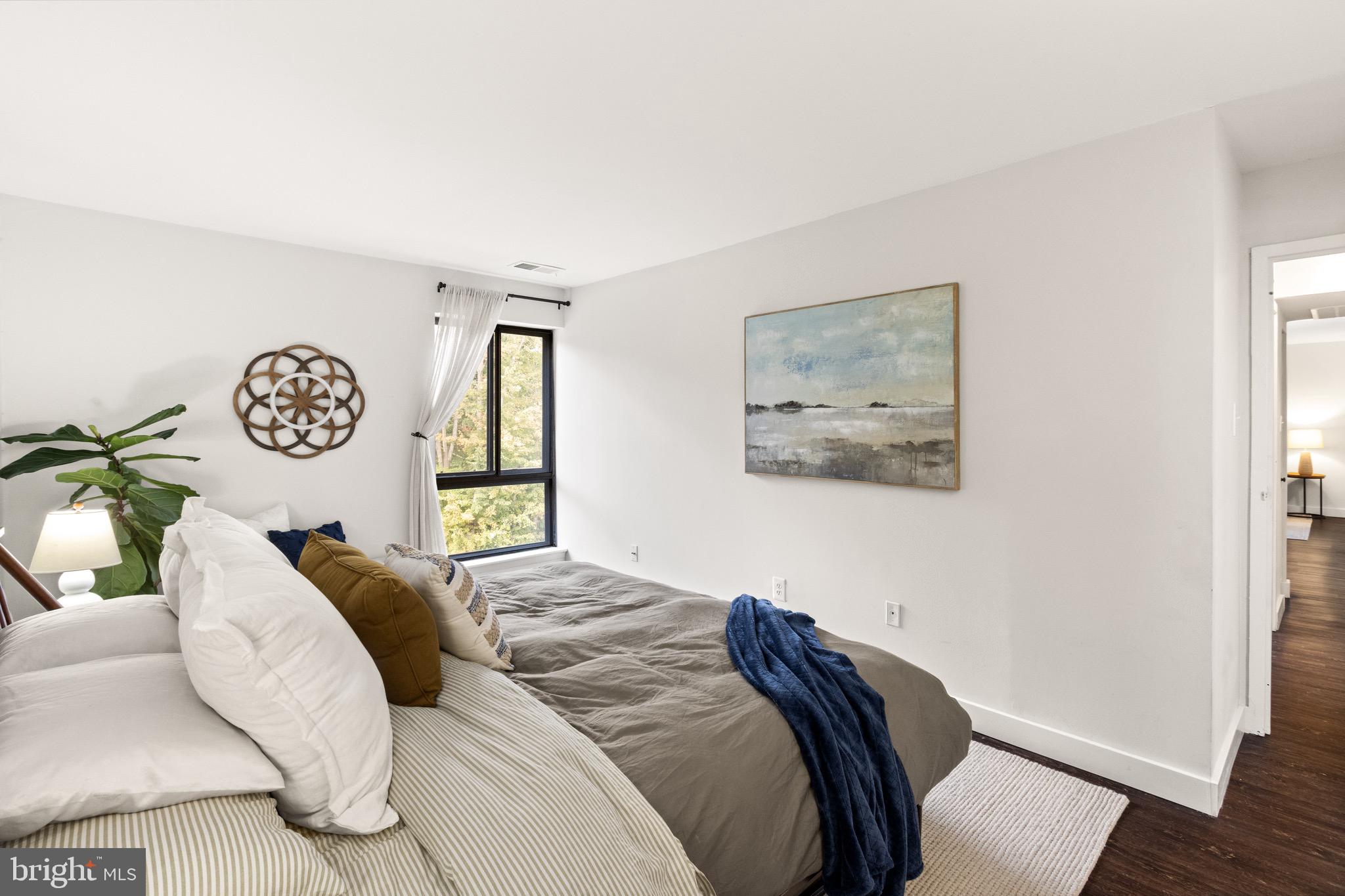 11240 Chestnut Grove Square, Unit 358 Reston, VA 20190 - Photo 21 of 31 a bed sitting in a bedroom next to a window with a bed
