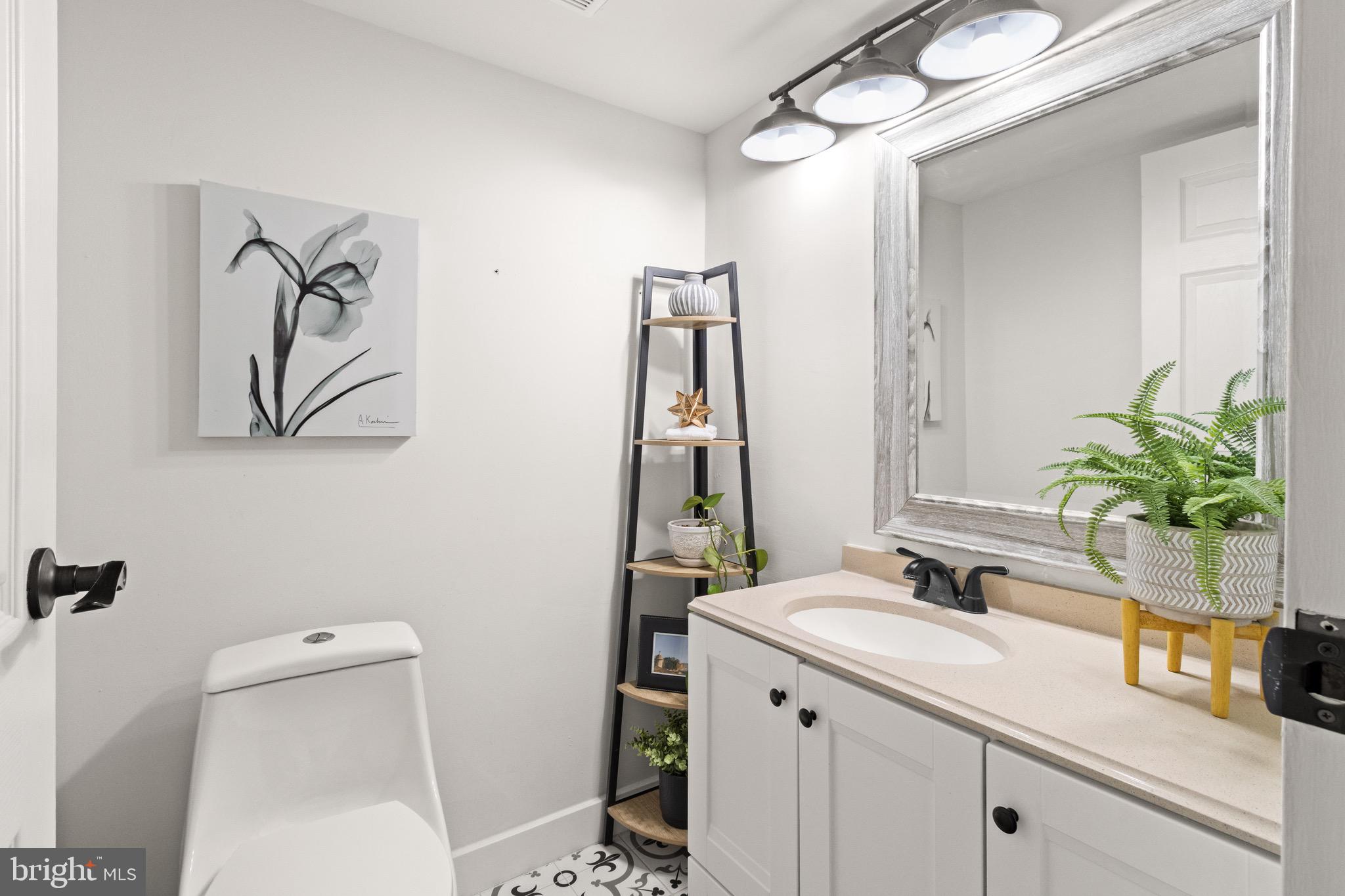 11240 Chestnut Grove Square, Unit 358 Reston, VA 20190 - Photo 25 of 31 a bathroom with a sink a toilet and mirror