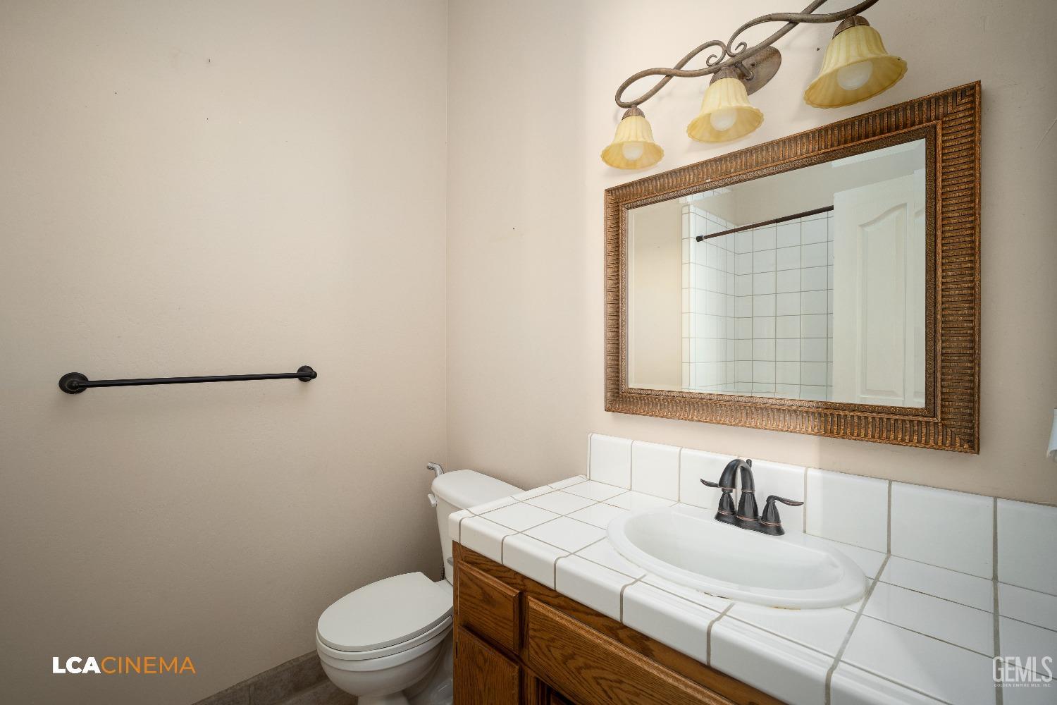 Undisclosed Address Bakersfield, CA 93312 - Photo 17 of 21 a bathroom with a sink a toilet and mirror