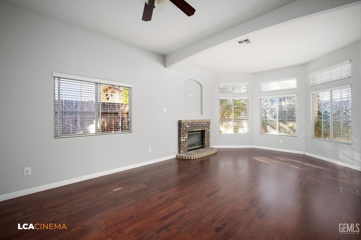 Undisclosed Address Bakersfield, CA 93312 - Photo 7 of 21 wooden floor fireplace and windows in an empty room