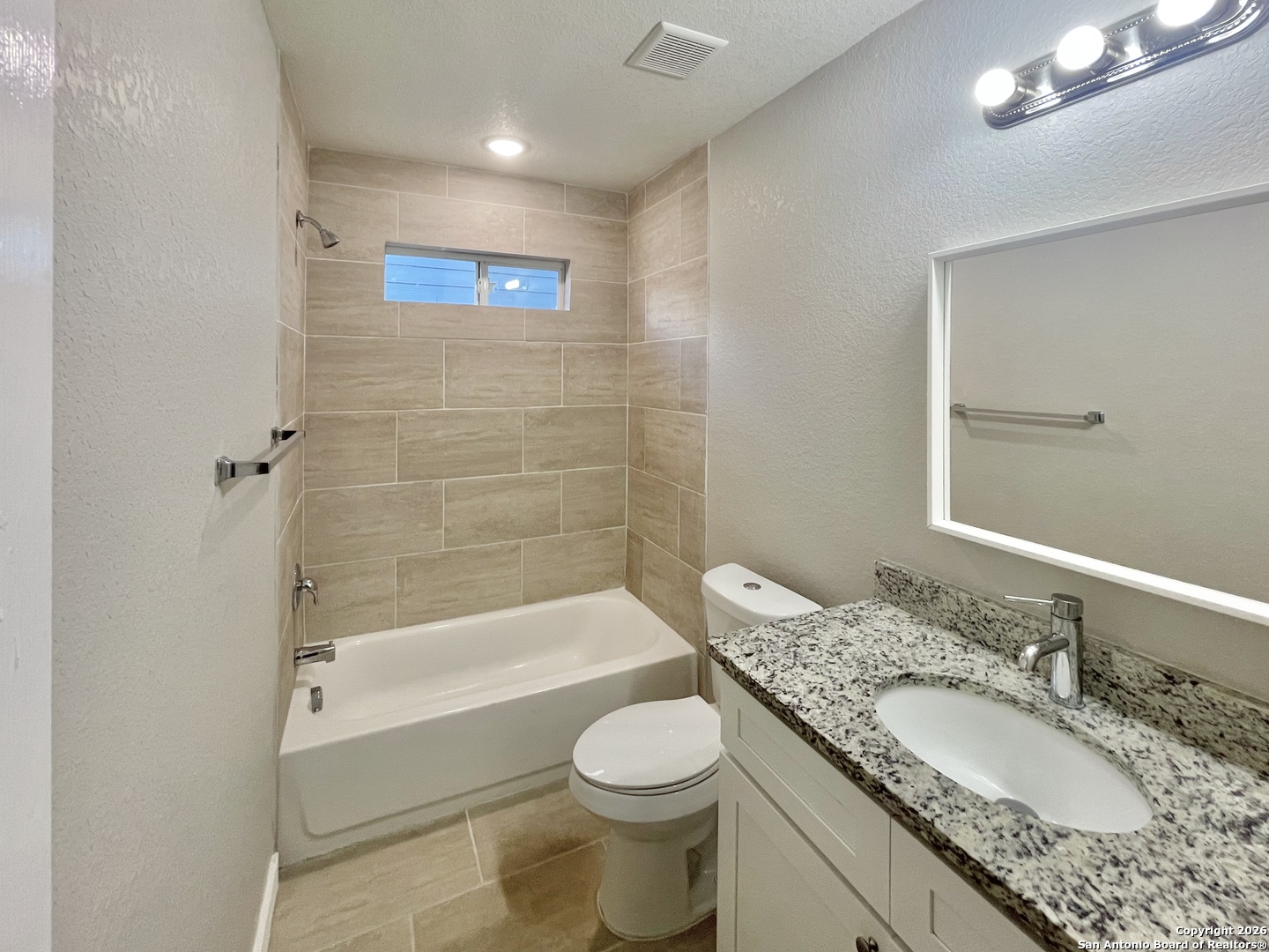 6938 Crestway Road, Unit 1 San Antonio, TX 78239 - Photo 11 of 16 a bathroom with a granite countertop toilet a sink and a bathtub