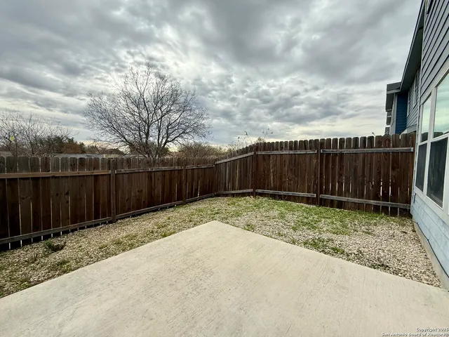 a view of backyard with wooden fence