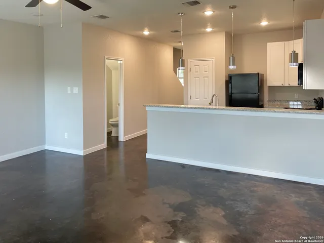 a view of kitchen with kitchen island microwave and refrigerator