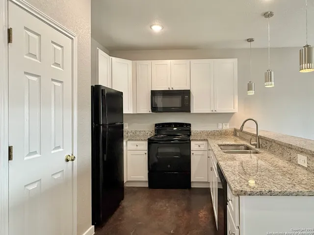 a kitchen with stainless steel appliances granite countertop a refrigerator a stove a sink and a microwave