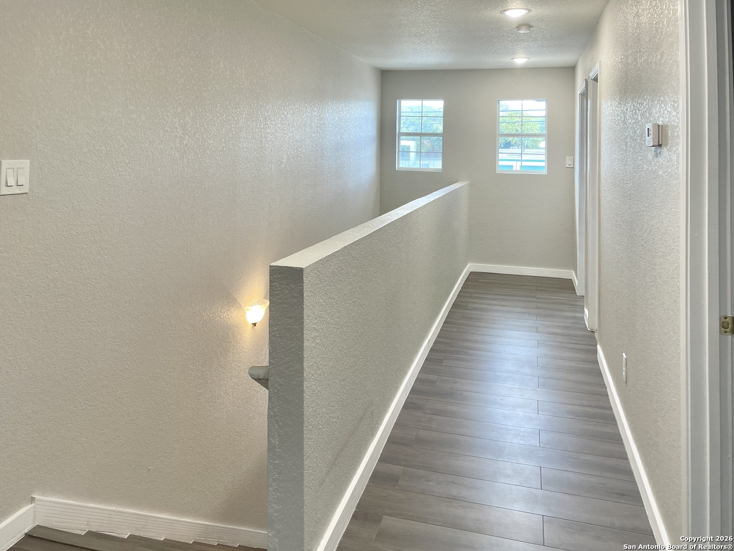 6938 Crestway Road, Unit 1 San Antonio, TX 78239 - Photo 8 of 16 a view of a hallway with wooden floor and staircase