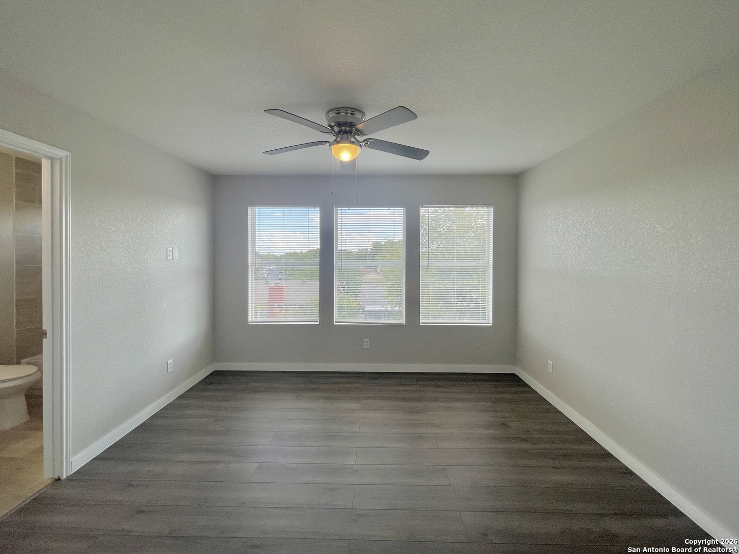 6938 Crestway Road, Unit 1 San Antonio, TX 78239 - Photo 10 of 16 wooden floor in an empty room with a window