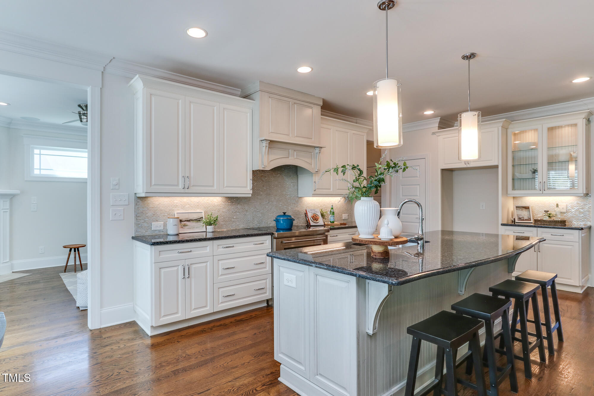 721 Shelley Road Raleigh, NC 27609 - Photo 13 of 46 a kitchen with kitchen island granite countertop a sink a center island and cabinets