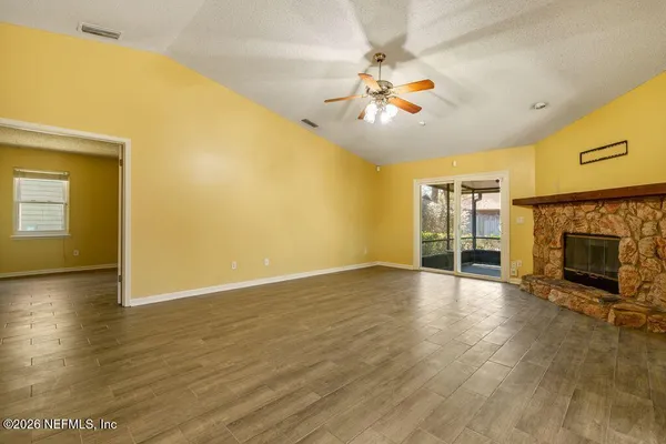 a view of an empty room with a fireplace and a window