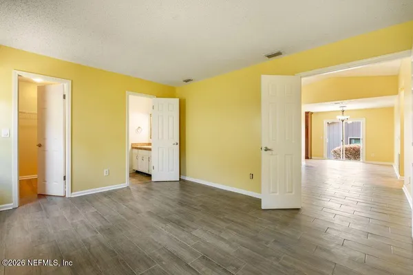 a view of a big room with wooden floor and windows