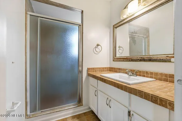 a bathroom with a granite countertop sink and a mirror