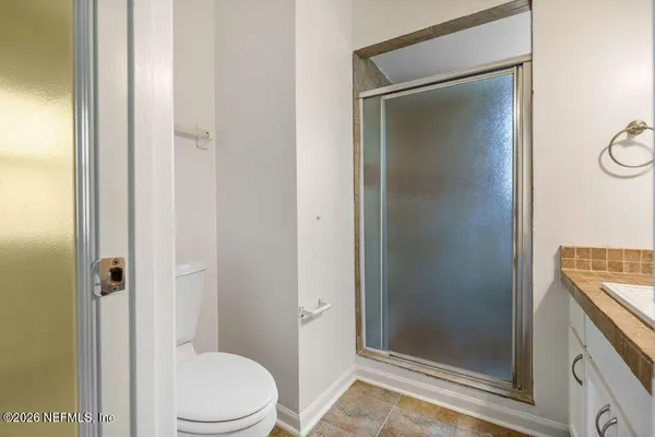 a bathroom with a granite countertop toilet and a sink
