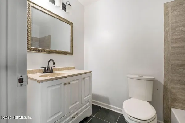 a bathroom with a toilet a sink and mirror