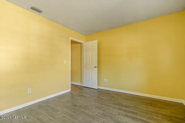 a view of empty room with wooden floor