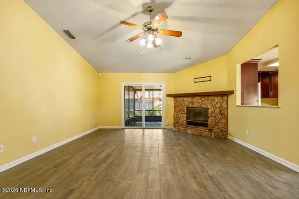 a view of an empty room with a fireplace and a window