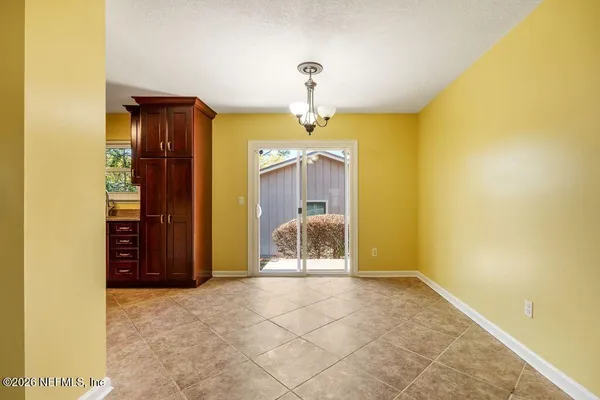 a view of a hallway with a cabinet and chandelier