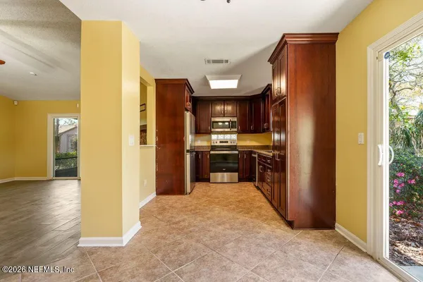 a kitchen with stainless steel appliances kitchen island granite countertop a refrigerator and a sink