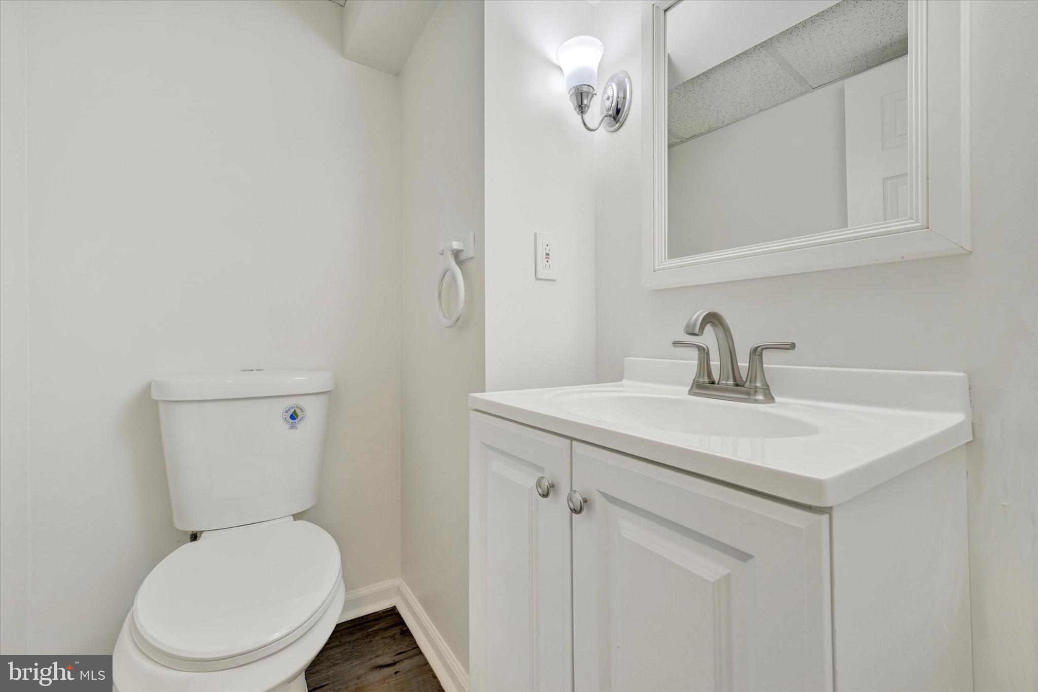 7007 Bank Street Baltimore, MD 21224 - Photo 15 of 18 a bathroom with a toilet sink and mirror