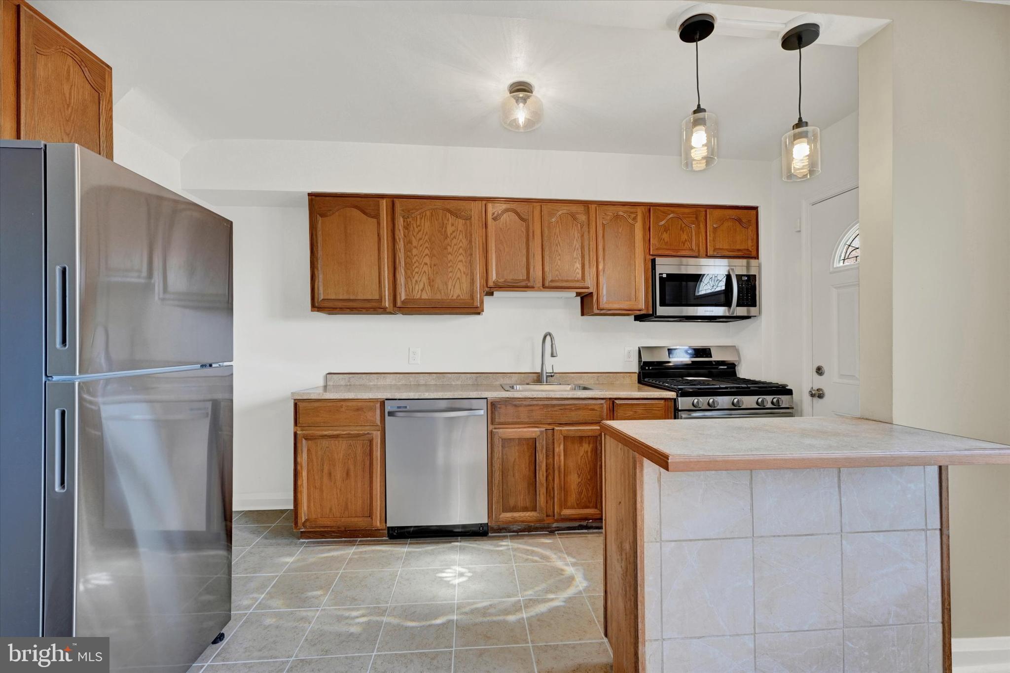 7007 Bank Street Baltimore, MD 21224 - Photo 7 of 18 a kitchen with stainless steel appliances granite countertop a refrigerator a stove a sink and a stove