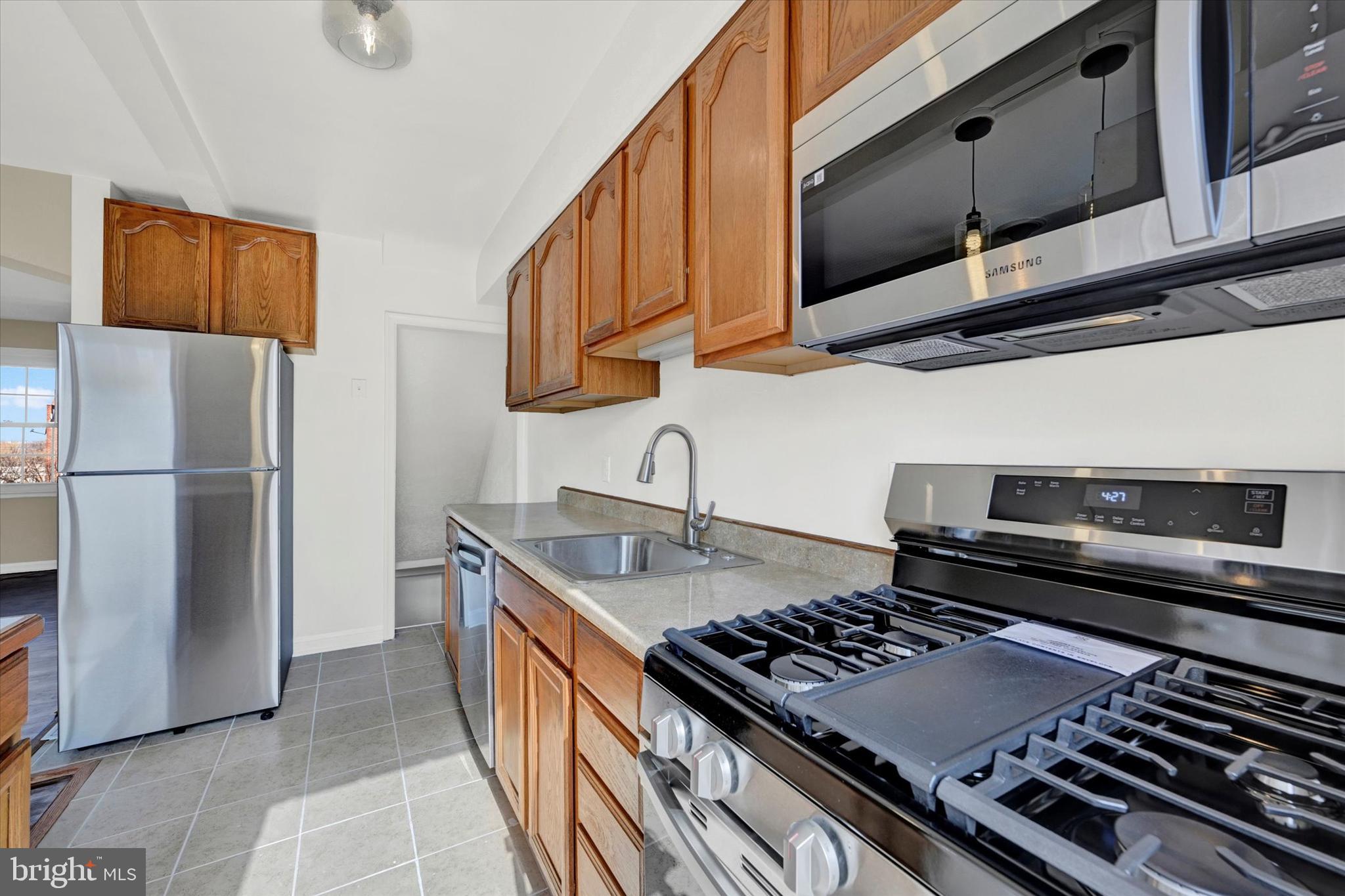 7007 Bank Street Baltimore, MD 21224 - Photo 9 of 18 a kitchen with stainless steel appliances granite countertop a stove a refrigerator and a sink