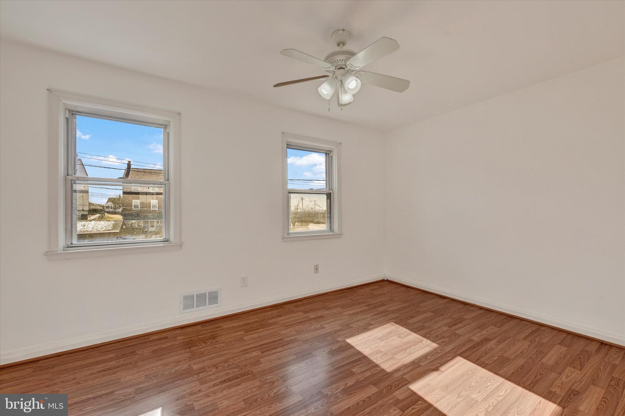 7007 Bank Street Baltimore, MD 21224 - Photo 10 of 18 a view of an empty room with wooden floor and a chandelier