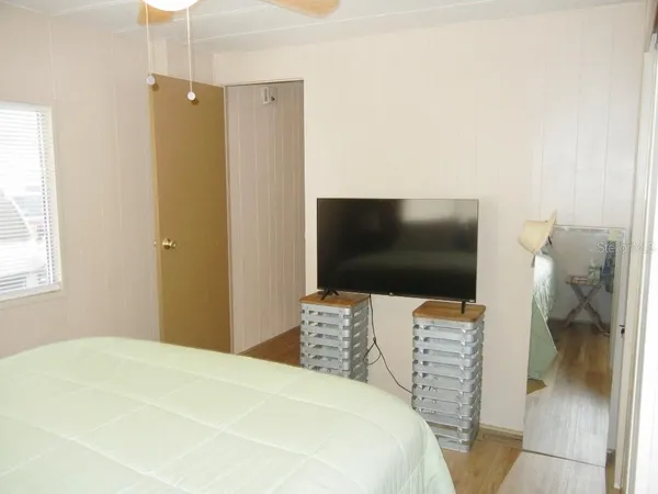 a bedroom with a bed and a flat screen tv