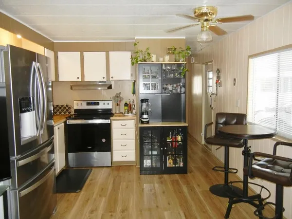 a kitchen with kitchen island a counter top space a sink stainless steel appliances and cabinets
