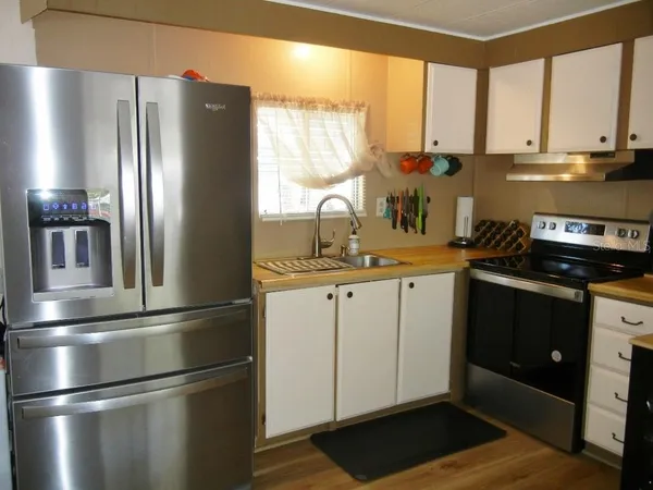 a kitchen with stainless steel appliances a refrigerator sink and cabinets