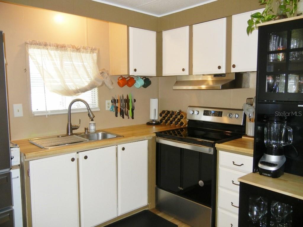 212 Rue De Pont Tavares, FL 32778 - Photo 8 of 36 a kitchen with stainless steel appliances a stove sink and cabinets