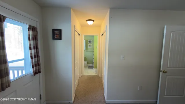a view of a hallway with wooden floor and cabinet